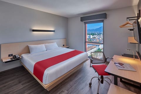 Wake up to sweeping skyline views beside a plush bed.