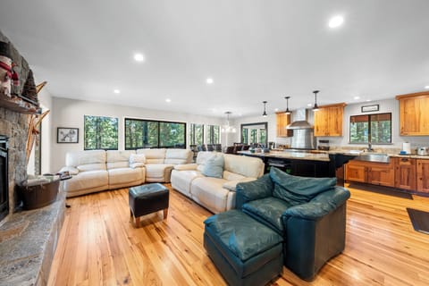 Bright and airy living area with comfortable sectional and forest views.
