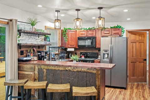 Warm wooden stools line the rustic wooden kitchen counter.