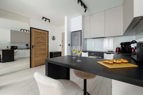 View from kitchen area with breakfast bar, modern appliances, and light flooring.