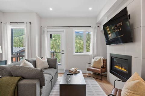 Living room with a smart TV, gas-lit fireplace, cozy seating options & access to the private balcony with a hot tub.