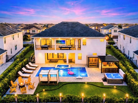 Twilight by the pool—heated spa glowing, loungers lined up, and a sunset that does half the work. The covered lanai with outdoor TV and dining keeps the party going long after the Florida sky turns pink.