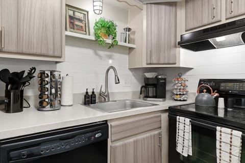 This modern kitchen is fully equipped with a premium knife set, spice rack, and all the essential cooking tools for your culinary needs.