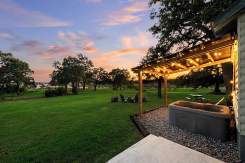 Peaceful backyard with string lights, hot tub, and stunning sunset views.