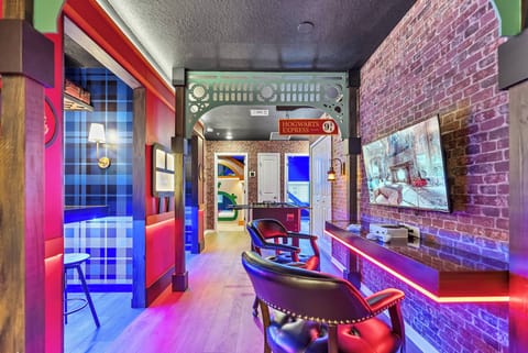 Welcome to our vibrant lounge with exposed brick walls and colorful accents. Relax in our cozy leather chairs, and enjoy the chic bar and modern TV, perfect for unwinding or entertaining after your day's adventures.