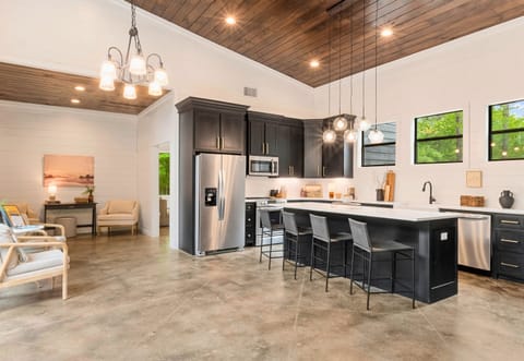 Your vacation meals are served with a side of style in this spacious kitchen and dining area, illuminated by trendy lighting and surrounded by tranquil views.