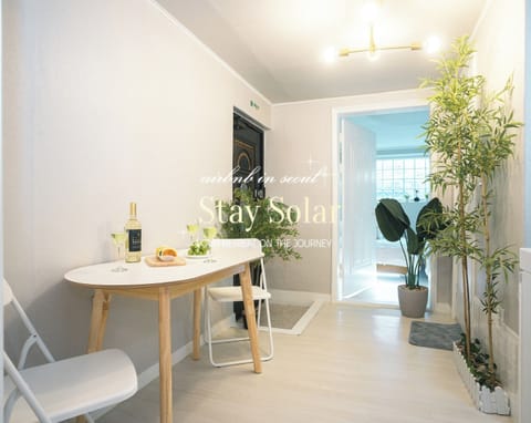 an entrance of Stay Solar, a bright living room, a table for at most 5 persons
