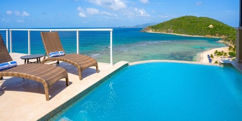 Dive into your private pool above a turquoise shoreline.