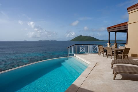 Sip cocktails by the water as islands drift on horizon.