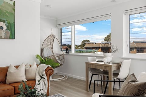 Unwind on the plush leather sofa or in a unique hanging chair. A modern dining table is perfect for enjoying meals.