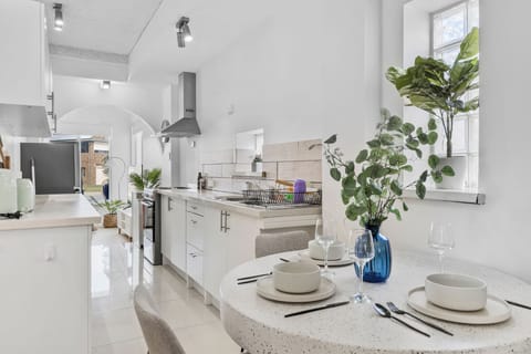 Get ready to create some culinary magic in this bright and beautiful kitchen! It's a clean, modern space with crisp white cabinets, shiny stainless steel appliances, and a fun breakfast bar for a quick bite. 