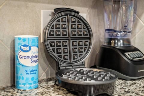 Kitchen equipped with a waffle maker and blender, perfect for preparing a delicious breakfast or smoothies. Conveniently located on the countertop, it's ready for guests to use and enjoy during their stay.