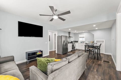 Bright and spacious living room with comfortable seating, modern ceiling fan, and open flow into the kitchen — perfect for relaxing after exploring downtown Fort Wayne.