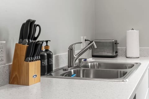 Double sink with modern faucet, toaster, and essential kitchen tools for easy meal prep.