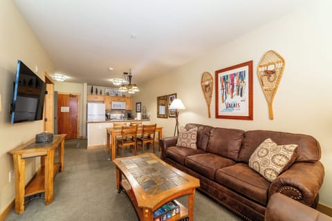 Bright open living room w/ TV, gas fireplace and private deck.