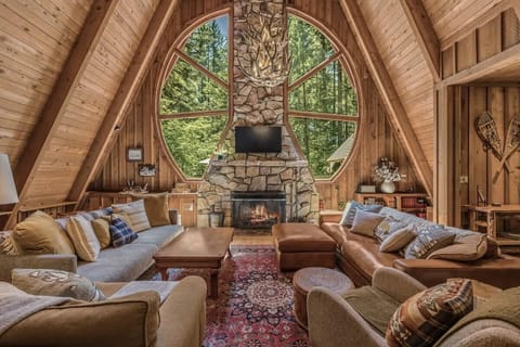 
Cozy up by the fire with stunning forest views! This spacious A-frame living room is perfect for relaxing and making memories. 