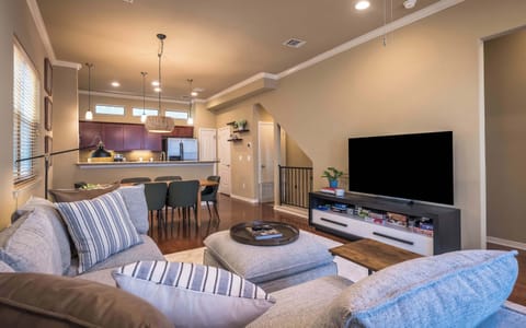 living room to kitchen view of couch, tv, dining room table and kitchen 