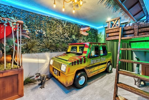 Immerse yourself in a whimsical experience with this themed room, showcasing a vibrant jungle backdrop and a colorful safari vehicle. The playful decor and unique lighting create a fun atmosphere ideal for families or groups.