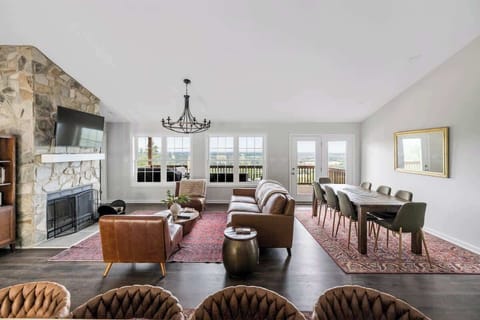 Open great room with stone fireplace, vaulted ceiling, and valley views