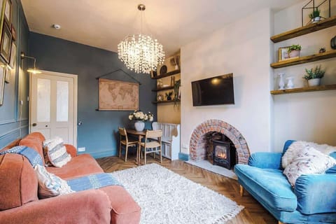 Elegant living area featuring a stunning brick-arch fireplace, contemporary blue and blush tones, and a chic gallery wall.