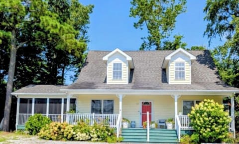 610 Castle Ct - Classic Bethany West Saltbox - This beautiful Cape Cod-style home features light yellow siding, dual dormer windows, and a welcoming red front door. The wide front porch and mature landscaping create a picture-perfect coastal exterior nestled in a quiet cul-de-sac.