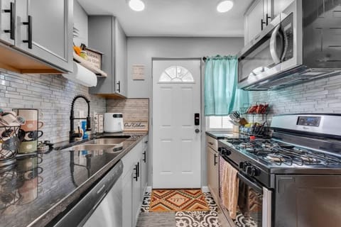 - Modern kitchen with stainless steel appliances   - Gas stove and microwave ready for home cooked meals   - Stylish backsplash with natural light from back door  
