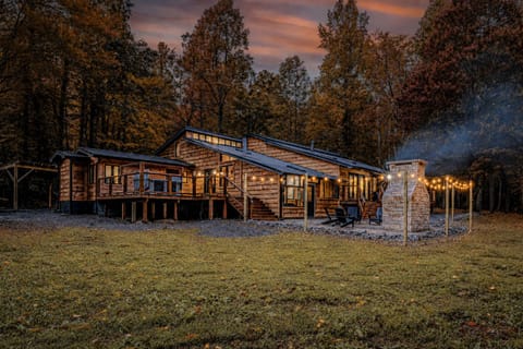 Your private mountain sanctuary comes alive at night with illuminated decks, a grand outdoor fireplace, and a spa-like hot tub designed for long, peaceful soaks under the stars.