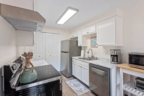 Fully stocked kitchen with coffee station, stainless appliances, and adjacent dining area - ideal for family meals.