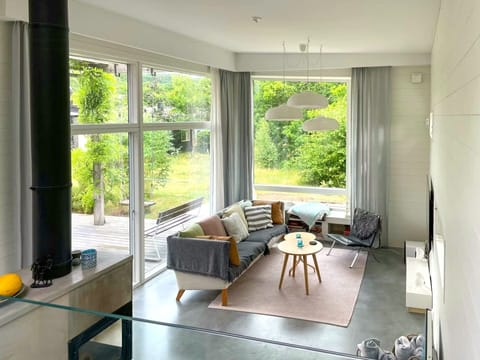 Bright Scandinavian living room with fireplace & floor-to-ceiling windows.