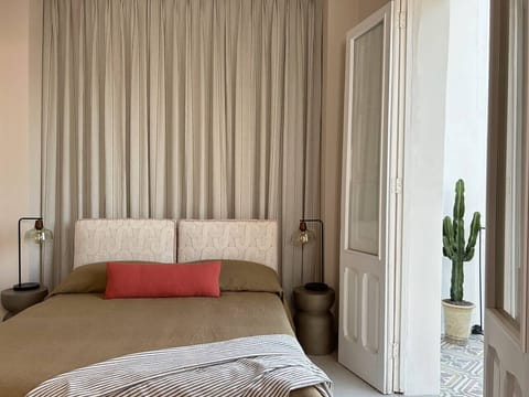 The secluded bedroom features luxurious textiles and its own balcony with views of the quiet neighbourhood 