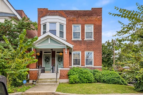 A straight-on daytime view showcases the home's brick facade and welcoming front porch.