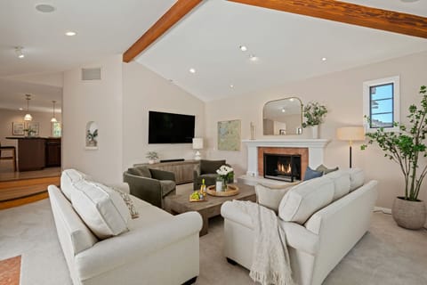 Warm and inviting living room featuring a fireplace and stunning exposed beam ceiling!