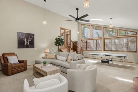 Sunken living room with ping pong table. Drop lights and ceiling fan. 