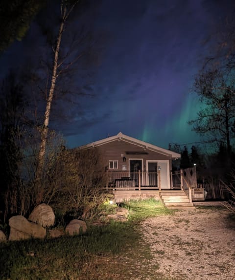 Sunset Cove illuminated under the Northern Lights — the perfect welcome to your lakefront getaway.