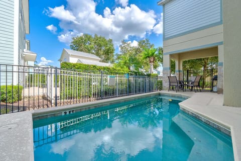 Private pool area with outdoor seating and grill under a covered patio
