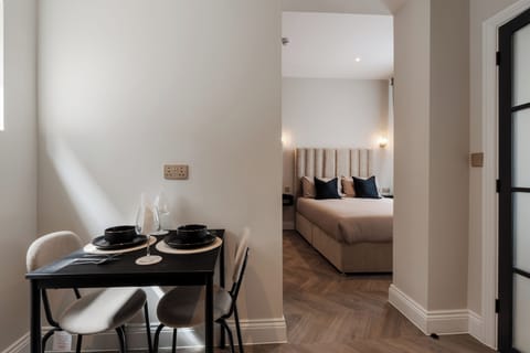 Compact yet practical, the kitchenette includes a two-seater dining space, microwave, toaster, kettle, fridge, and all essentials like tea, coffee, sugar, glasses, and cutlery. A wardrobe, wall mirror, iron, hairdryer, and board add extra convenience
