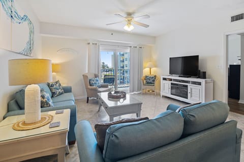Unwind in this coastal-inspired living room with plush seating, natural light, and balcony access—perfect for enjoying ocean breezes and relaxing after a fun-filled day at the beach.