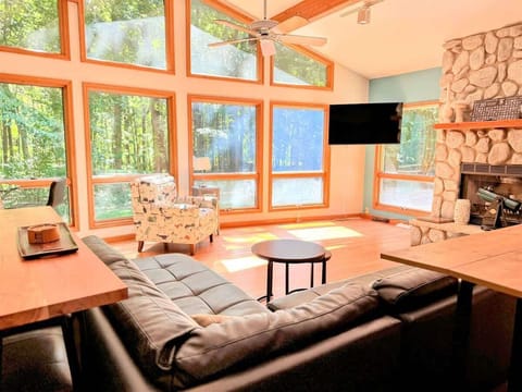 The view from every seat is pure Michigan magic: vaulted ceilings, a wall of windows, and a cozy stone fireplace set the tone for a peaceful, light-drenched retreat.