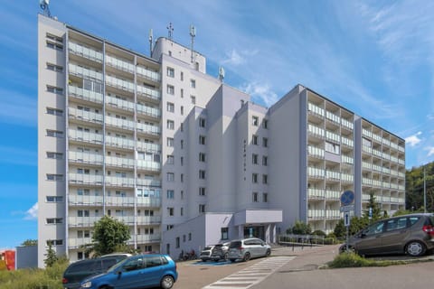 The building’s facade with a wide driveway and parking area offers convenient access for guests arriving by car.