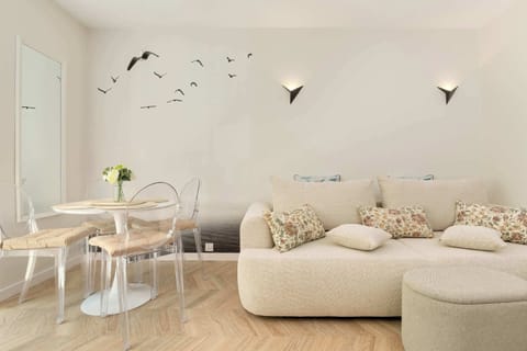 A bright living room with soft armchairs and poufs creates a cozy space for shared relaxation in natural light