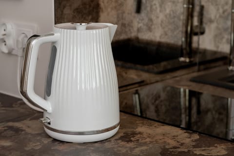 A stylish kettle on the stone kitchen countertop combines functionality with modern design.