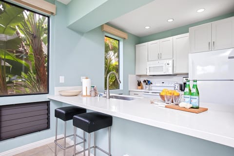 Fully equipped kitchen with island seating and modern white cabinetry GCH-121