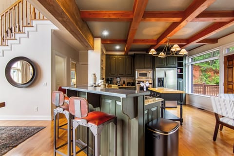 Rustic charm meets modern style in this wood-beam kitchen with stainless steel.