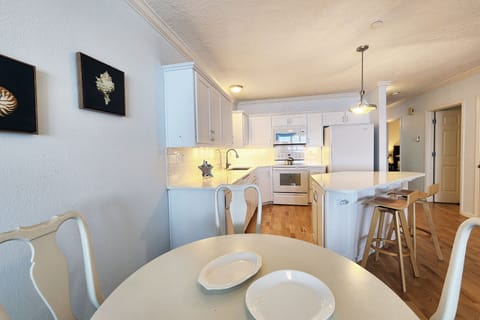 Cooks in the kitchen while others keep them company.