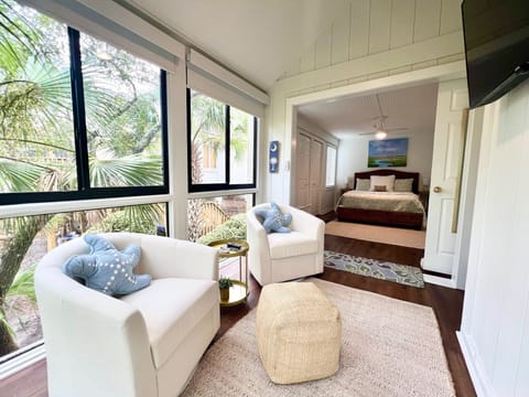 Enjoy a good book or the lush, tropical view from the bright sunroom, featuring comfy chairs and starfish pillows.