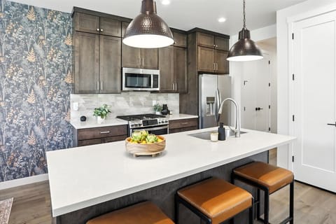 The kitchen island is a real multitasker. It's for your morning coffee, a quick bite, and the best spot to tell us about your day. Pull up a stool!