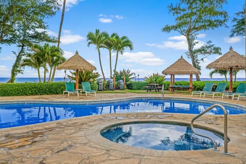 Relax by your private pool and hot tub while swaying palms frame ocean views beyond tropical cabanas.