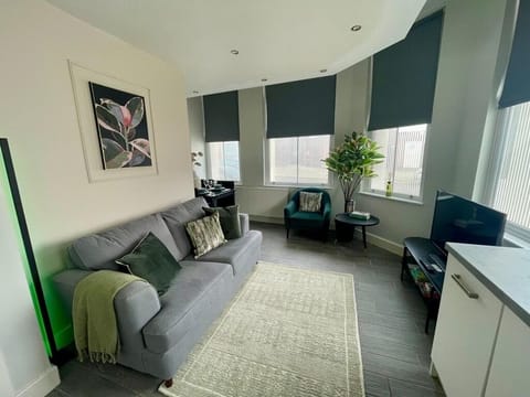 A relaxing open-plan living space with a Smart TV offering Netflix and a comfortable sofa bed. The layout includes a small dining nook and a combined kitchen and lounge area, creating a practical and inviting place to unwind.
