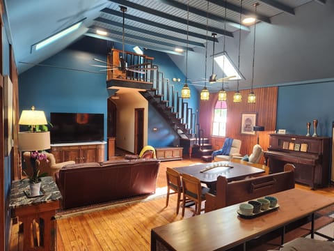 Open concept living/dining area with 75" Roku TV and skylights 