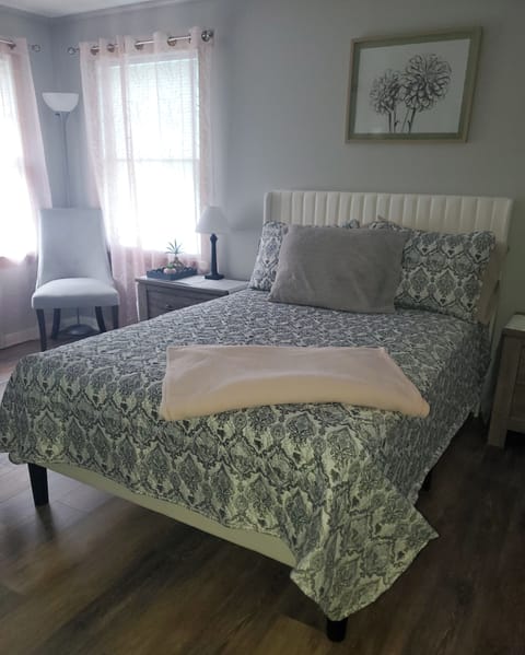 This full bedroom has: double closet,tall dresser, 2 windows and nightstands. 